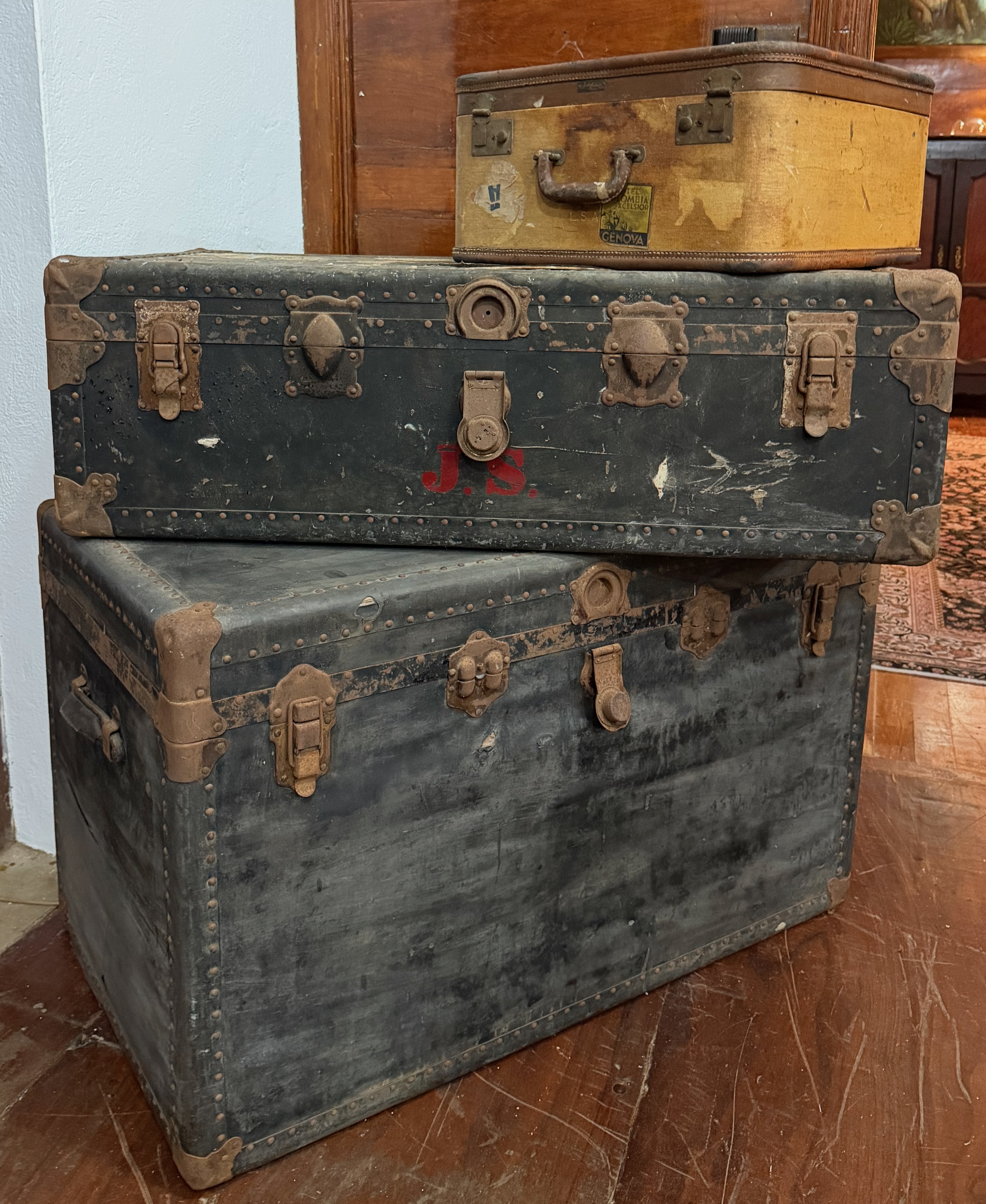 Stacked travel trunks under the portrait of John Dana Archbold